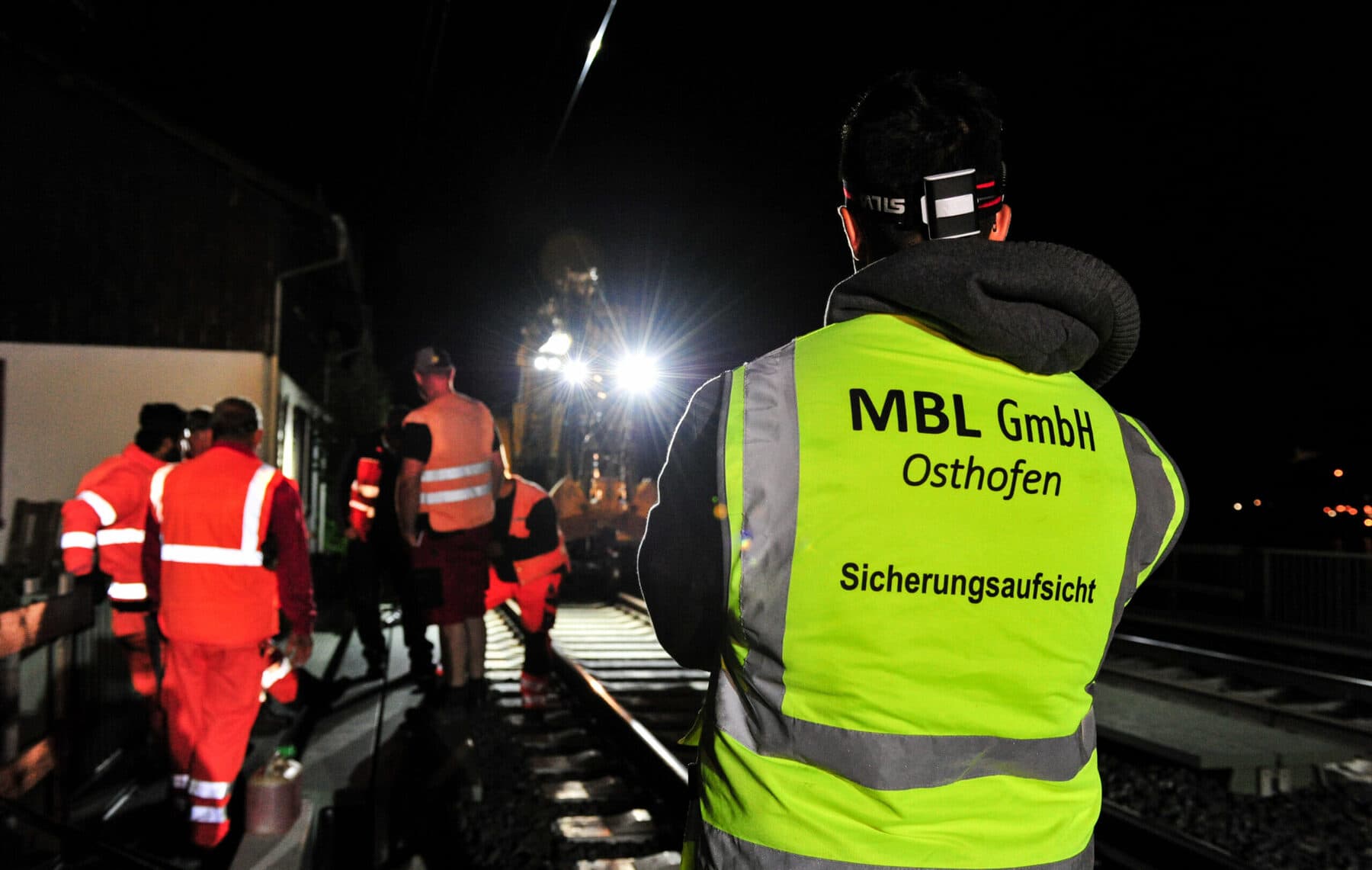 MBL-Sicherungsaufsicht in gelber Warnweste bei nächtlicher Gleisbaustelle