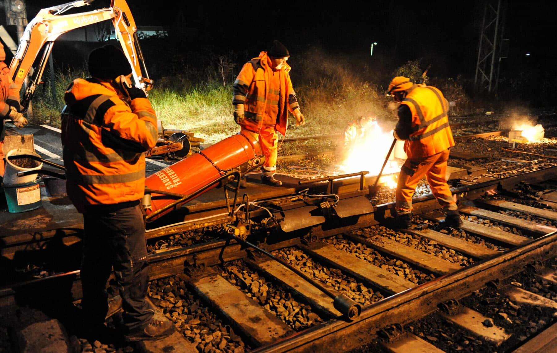 Thermitschweißung an einer Schiene bei Nacht