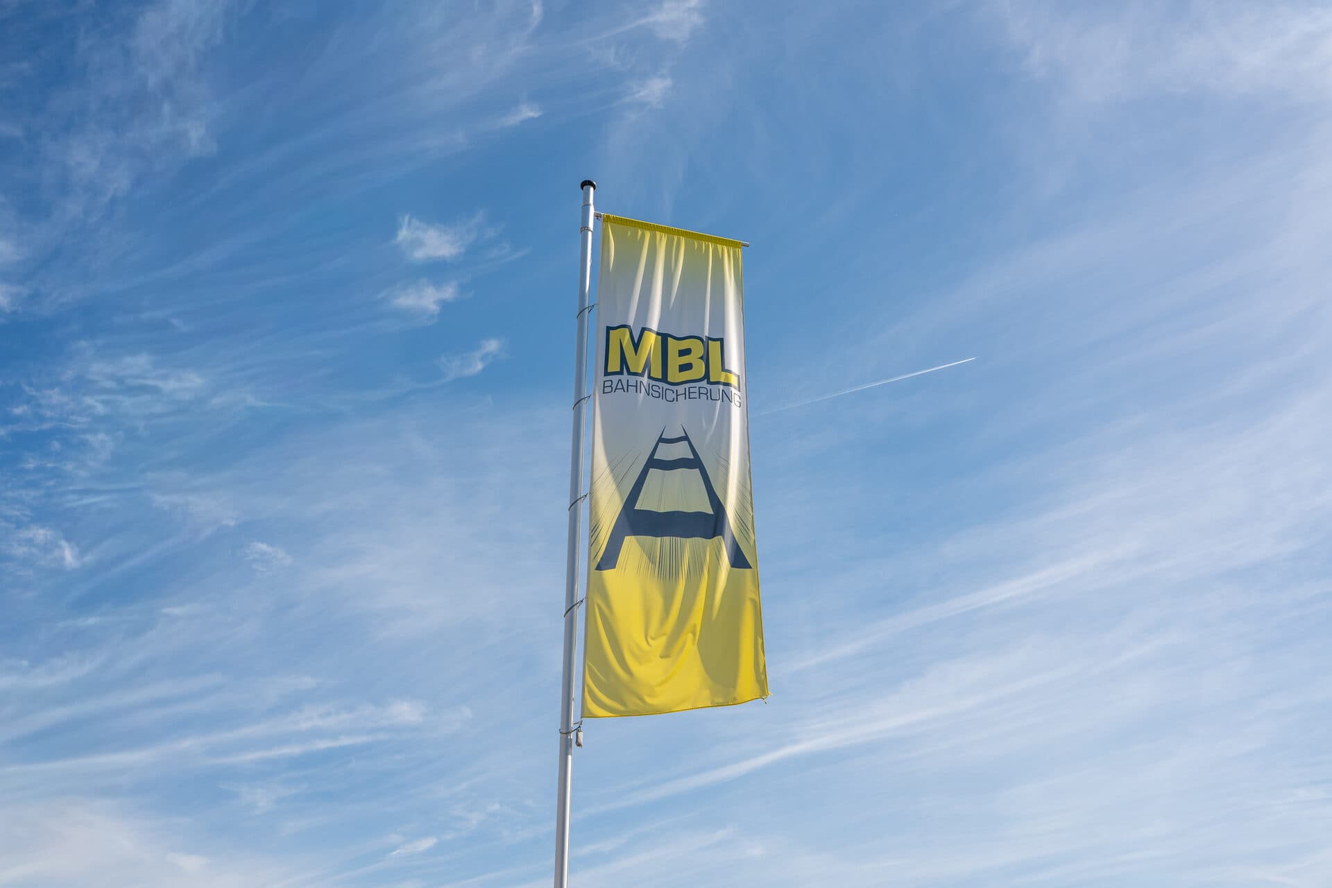 Gelbe MBL-Bahnsicherung Flagge vor blauem Himmel
